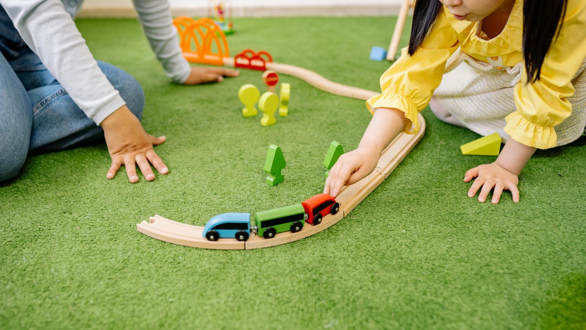 2 kinderen spelen met houten trein