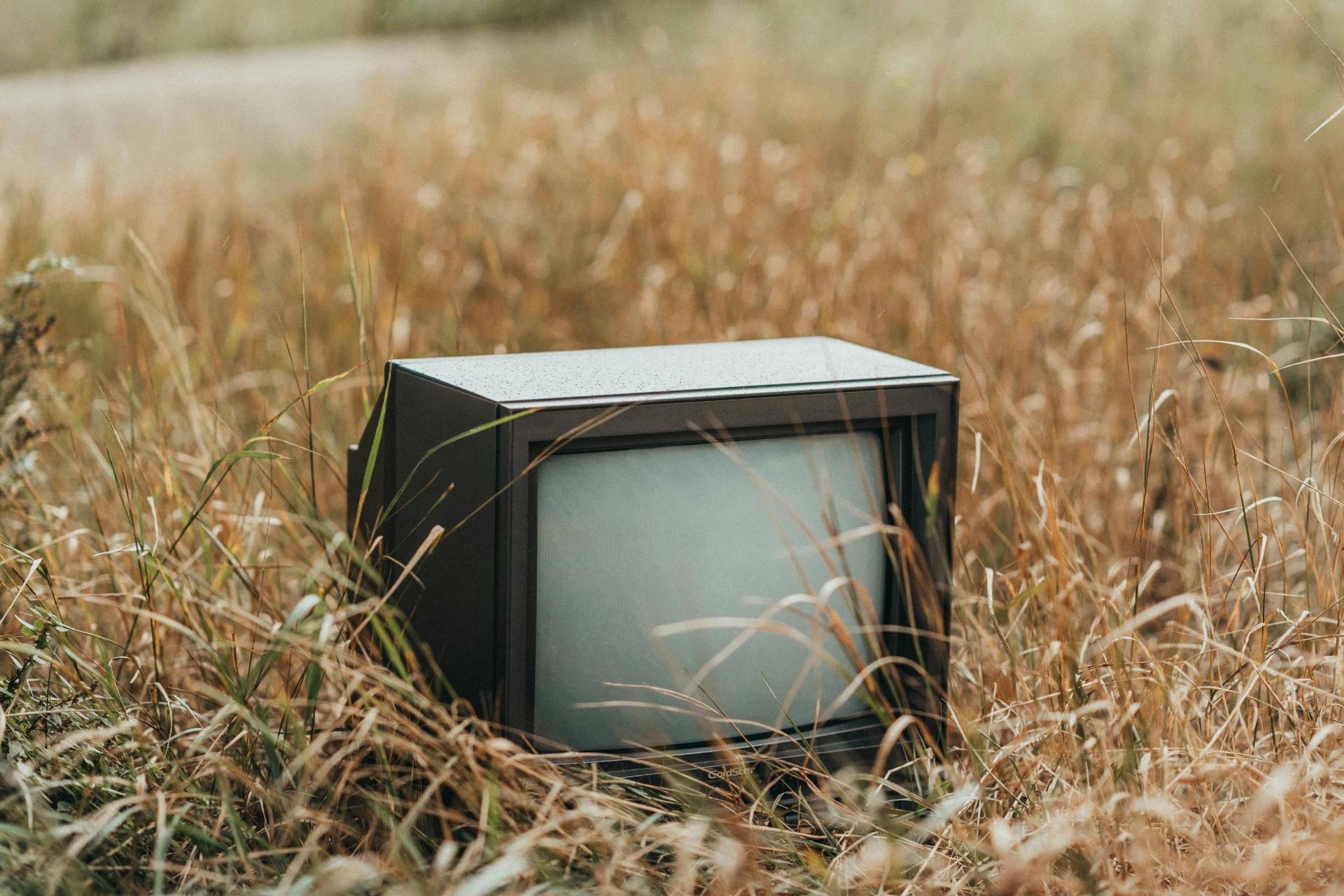 Televisie achtergelaten in een grasveld